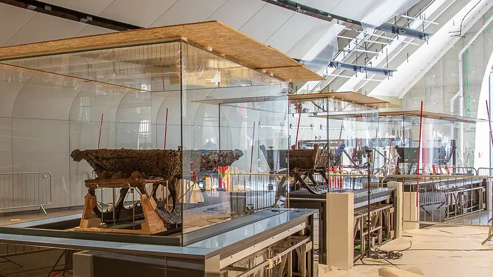 Three sledges from the Viking Age placed in display cases.