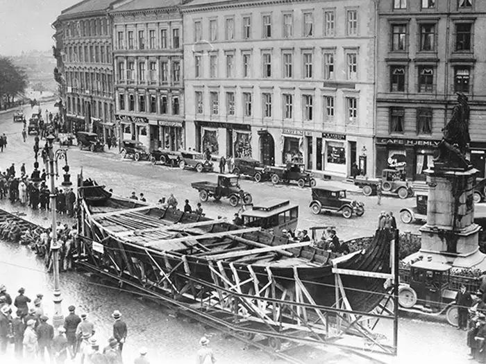 A historic black-and-white photograph of a Viking ship being moved on rails through Oslo to Bygdøy.
