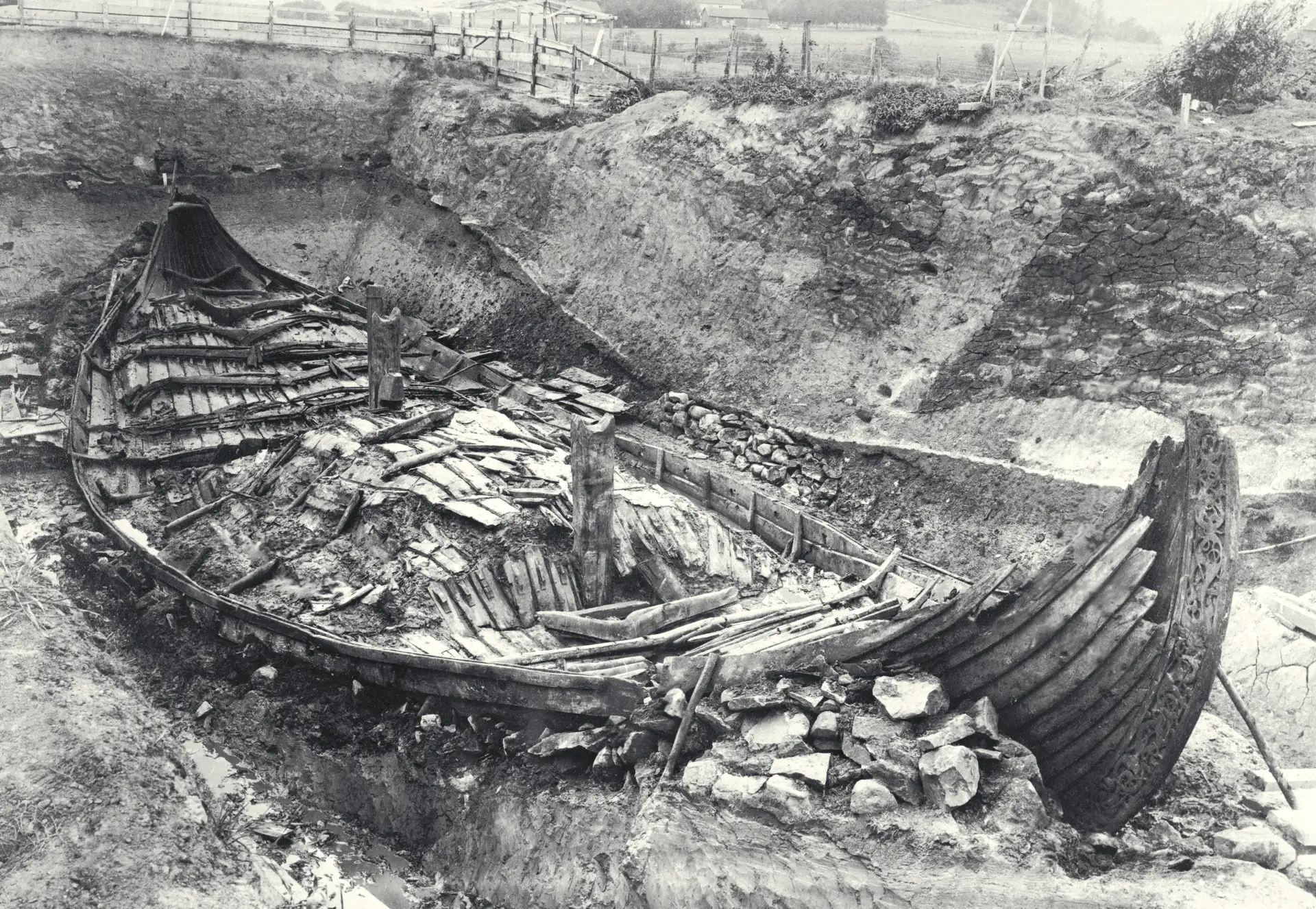 Historical black and white photo of the Oseberg Ship being excavated